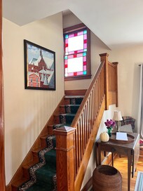Front stairs.note the front stairs lead to second floor section that has three bedrooms and full bathroom. Also leads to a sitting room with futon and computer , and then to a back bedroom. There is also a back staircase.
