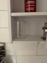 Glass holding up bathroom cabinet shelf