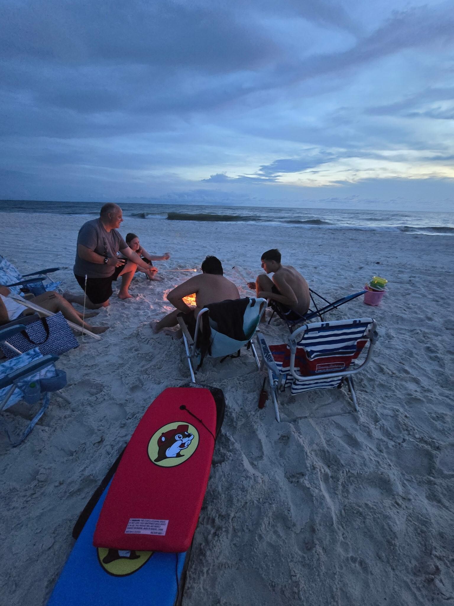 Fire on the beach making smores. 