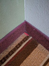 Chewed gum in room corner, no obstruction of sight, plainly visible.