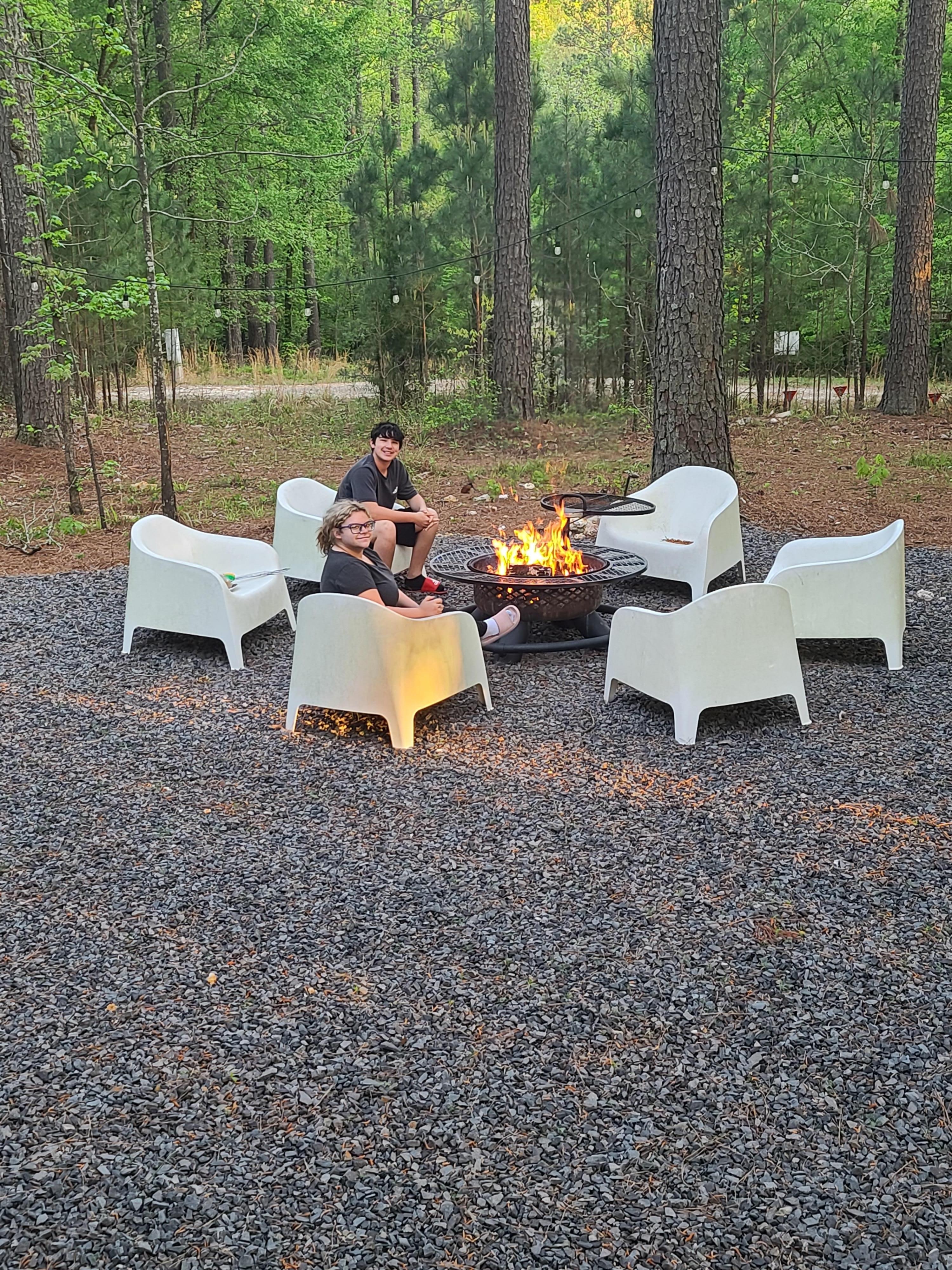 Kids enjoying the outdoors next to the fire.