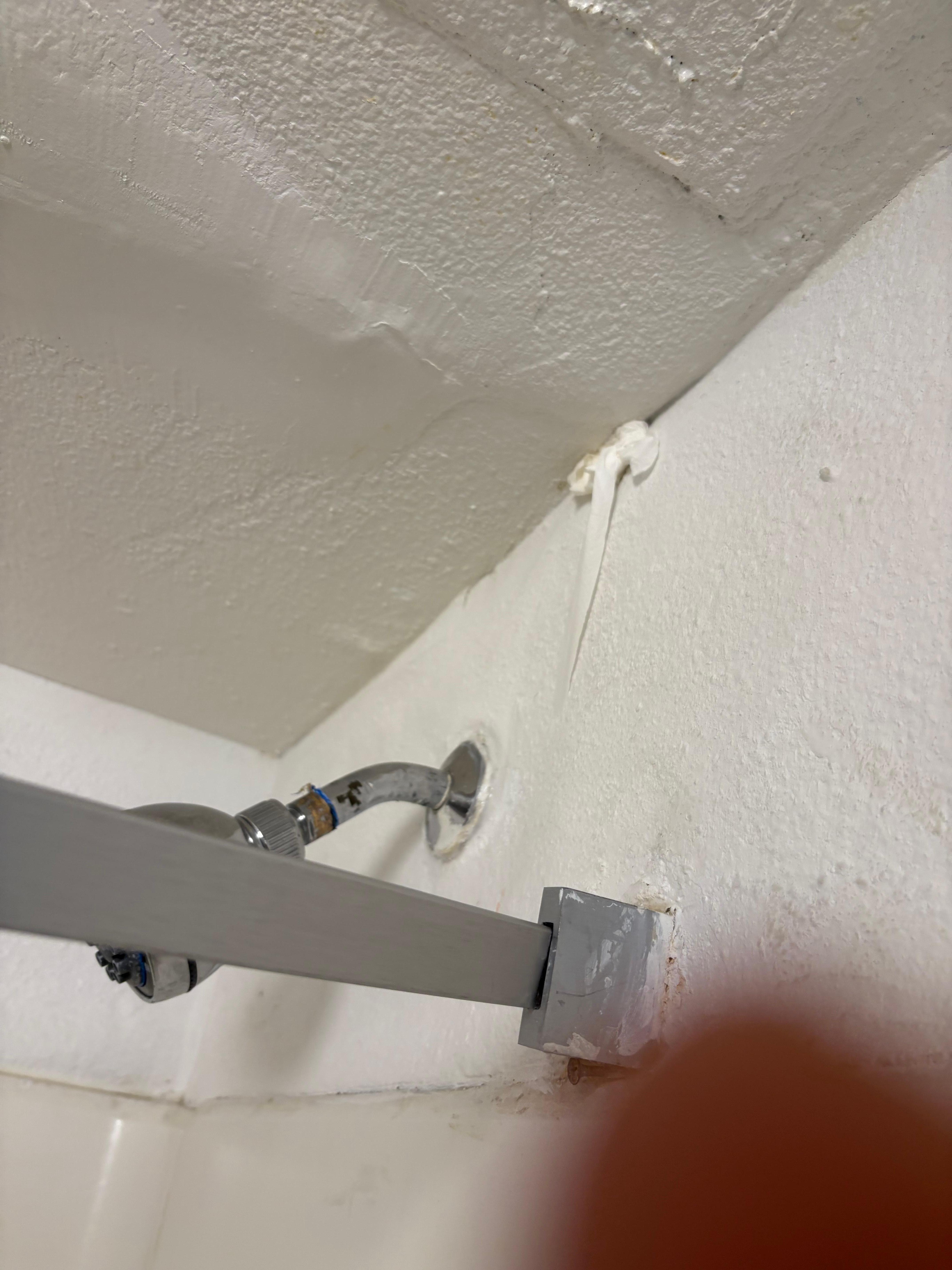 Toilet paper shoved in a hole in the bathroom ceiling 