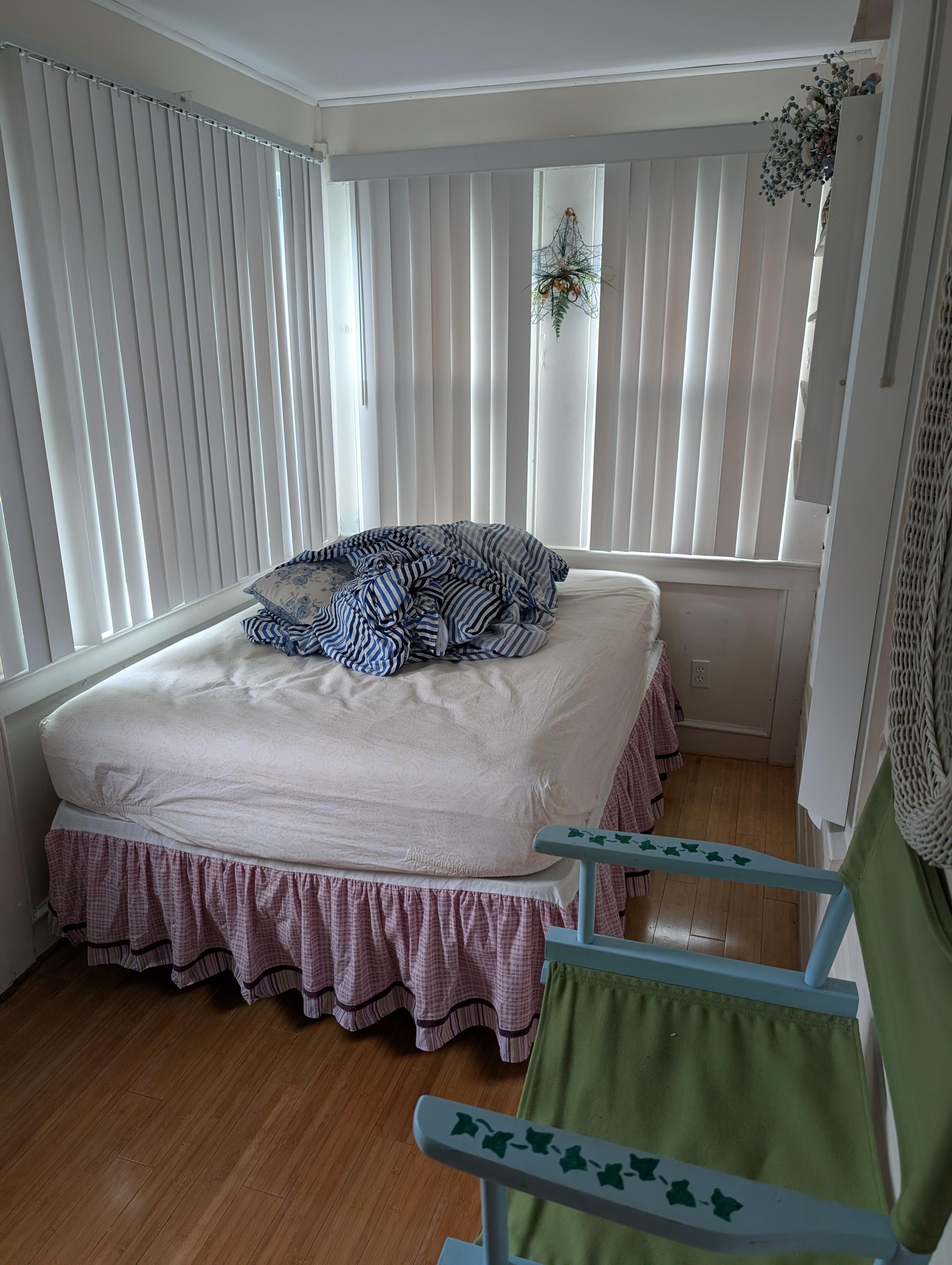 The bed in the front bedroom, surrounded by the windows. We had stripped the bed before leaving, it was made up nicely when we arrived. 