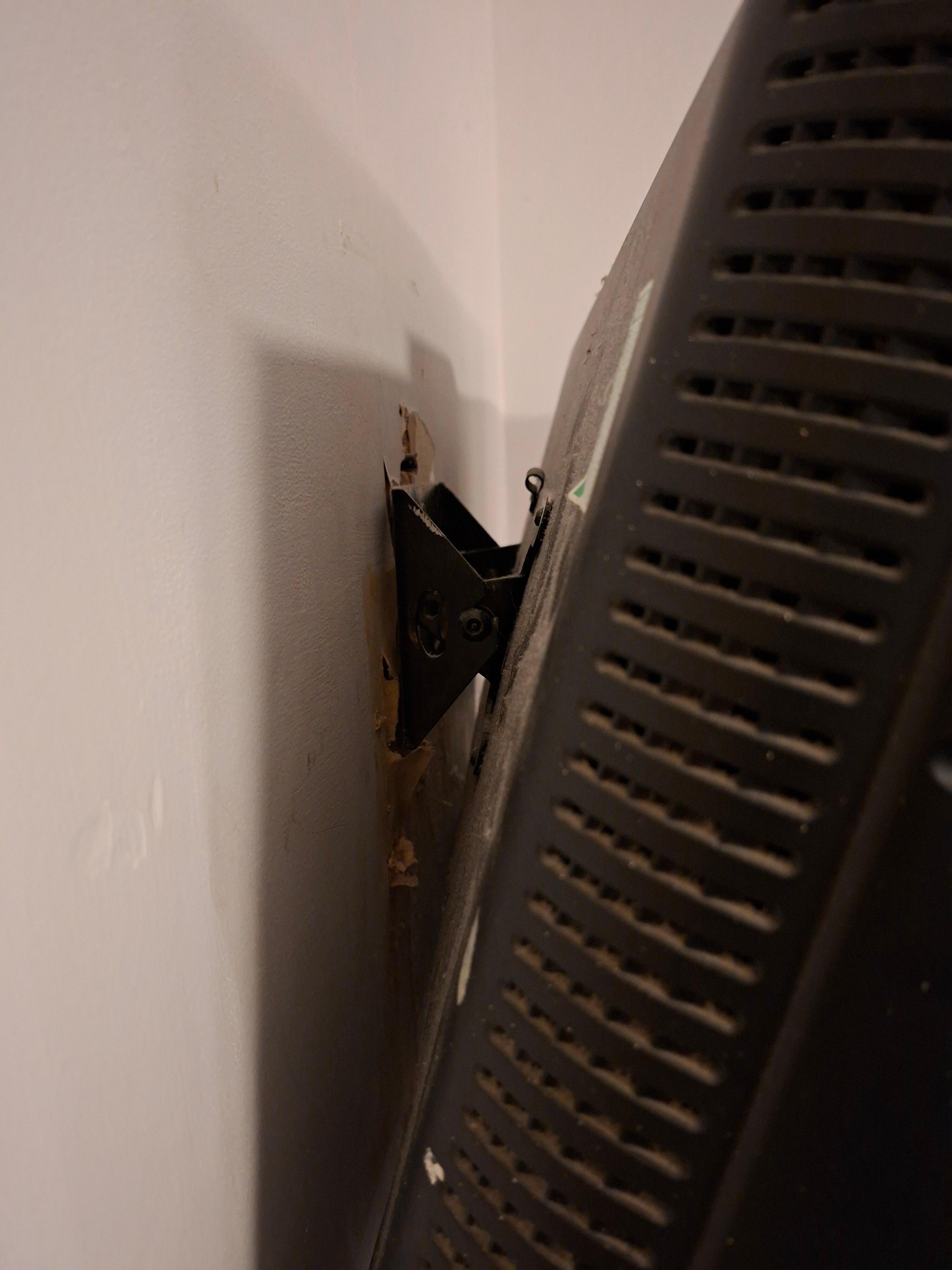 Tv hanging off the wall, not secured