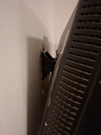 Tv hanging off the wall, not secured