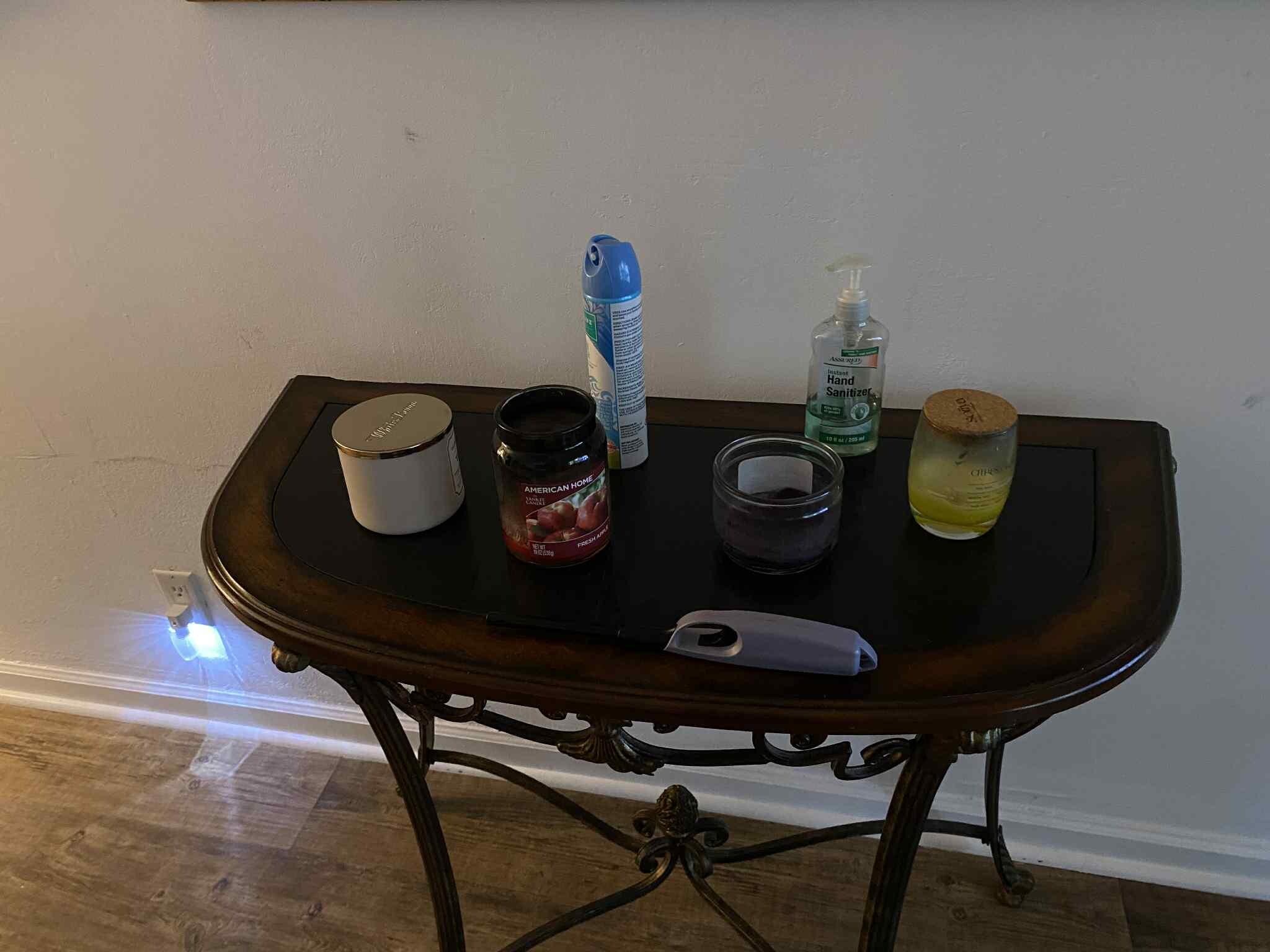 Table with candles, room spray and lighter.