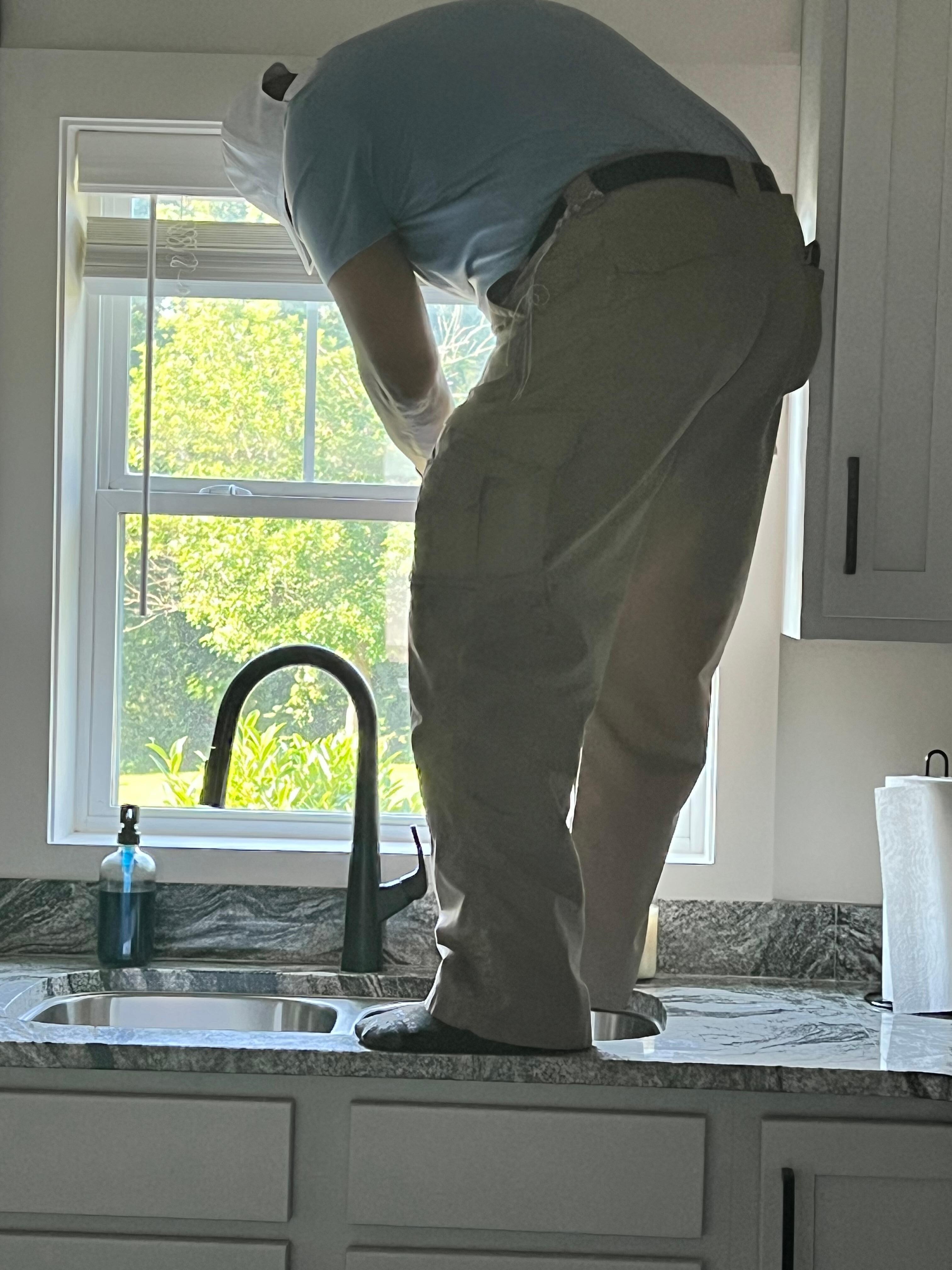 Trying to lock the kitchen window after a stranger tried to get in from outside