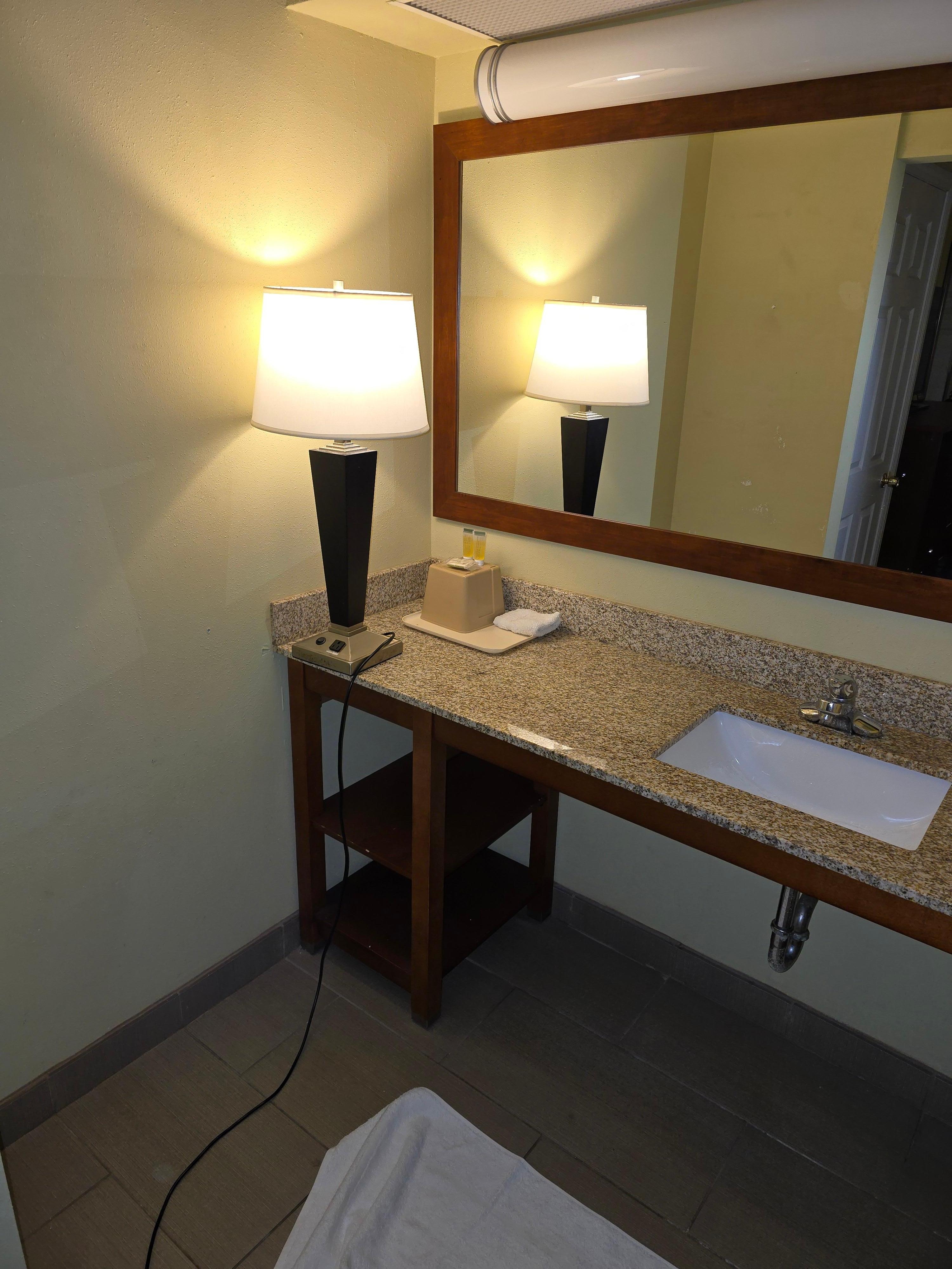 Lamp on sink because lamp on sink because the light over the mirror did not work. Someone could be electrocuted. 