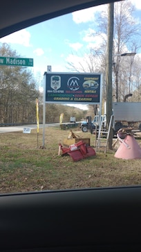 Roadside sign, you will turn here, then turn right, onto gravel lot, before following the gravel road down towards the left.