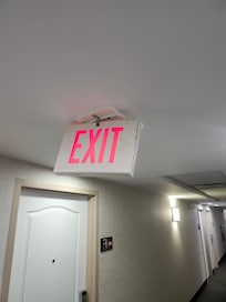 exit sign falling apart in hallway.