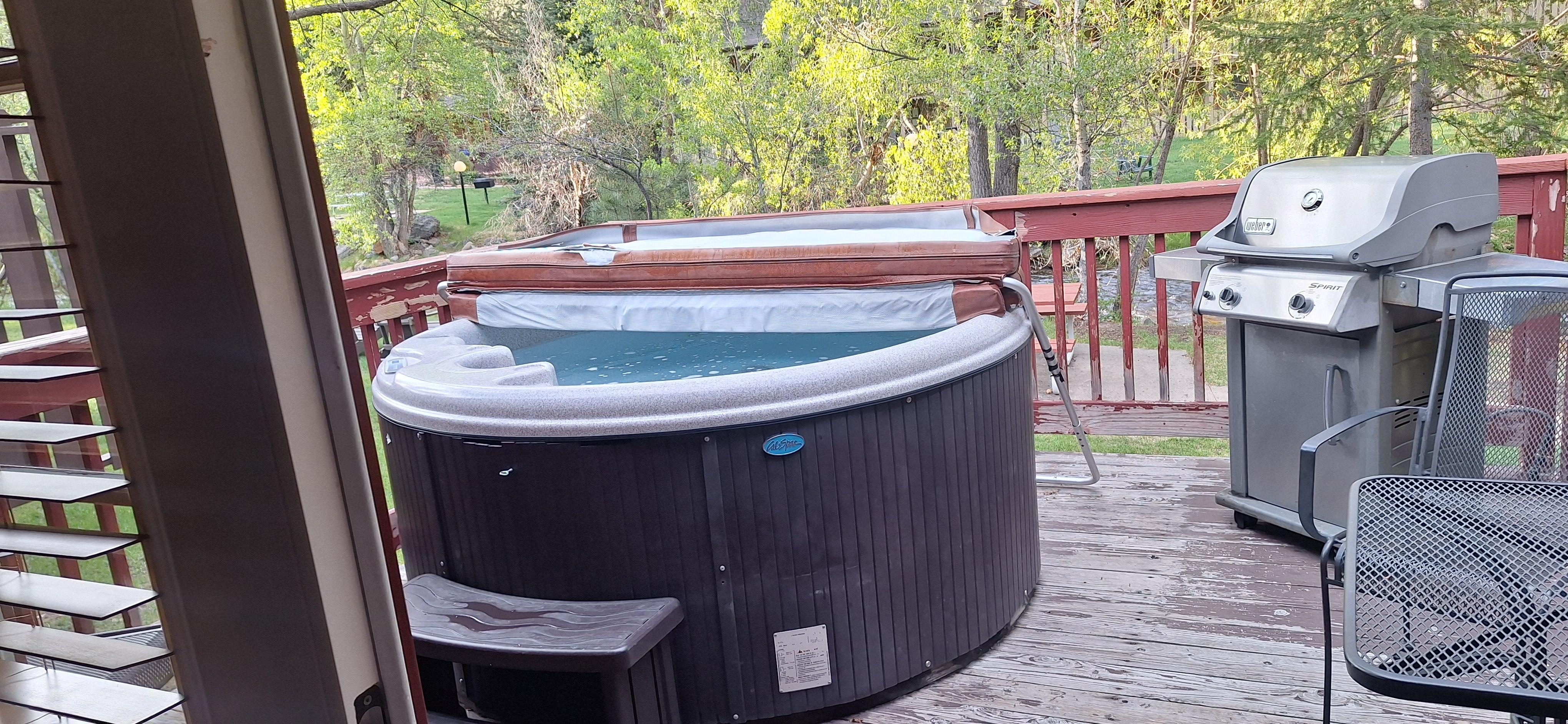 The deck with hot tub, grill, and patio furniture. 