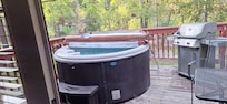 The deck with hot tub, grill, and patio furniture.