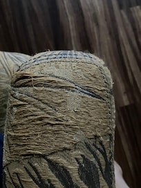 Worn out couch with fraying thread