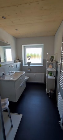 Neues Bad mit großem Spiegelschrank und viel Licht.