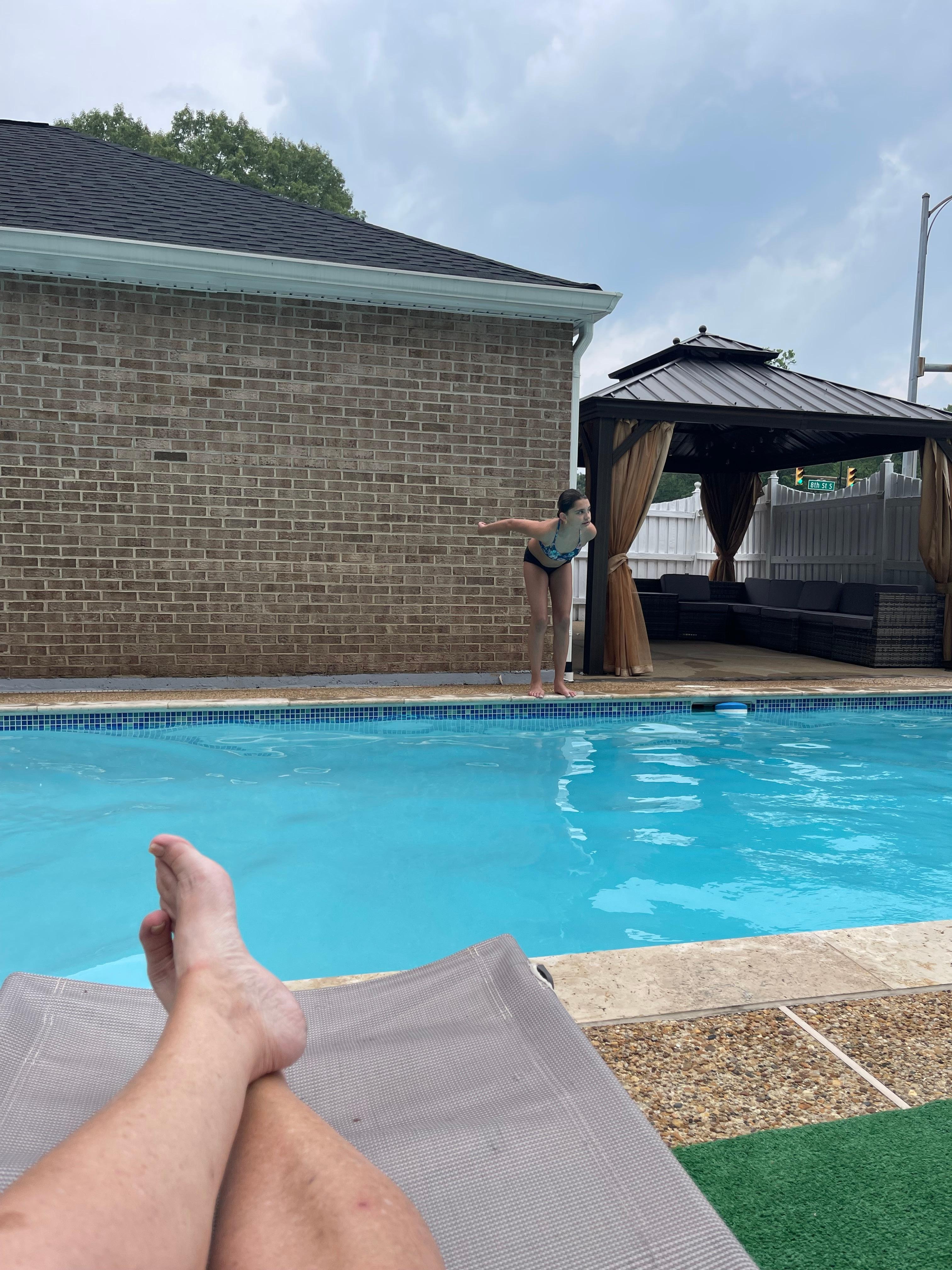 Sitting at pool side enjoying the afternoon after a long drive. 