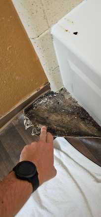 flooring peeling up in bathroom, rust stains and hole in tub