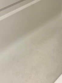 The tub is dirty on the bottom and sides.