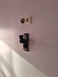 Parede com tomadas aparecendo (sem tv na sala).