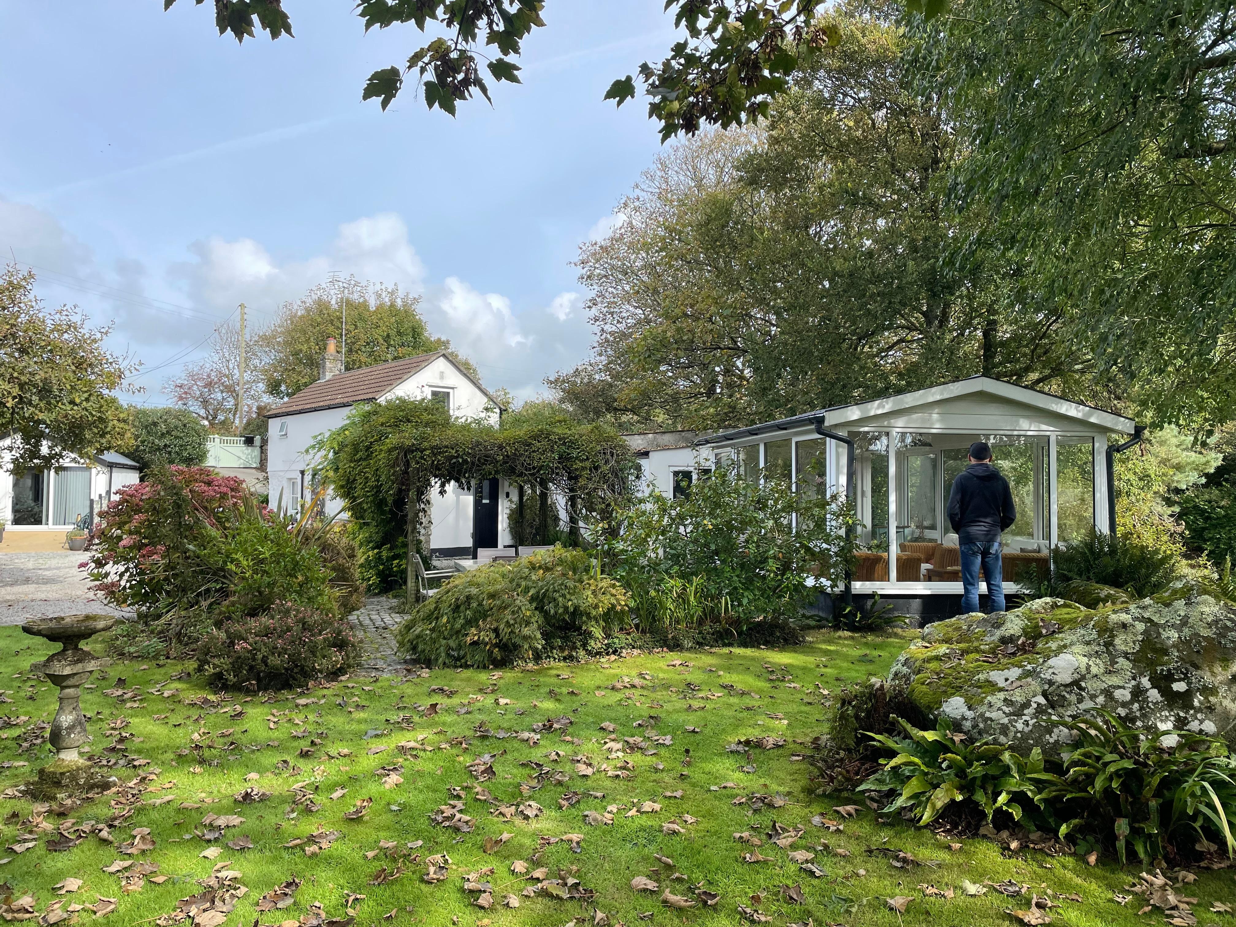 The cottage, summerhouse and part of the garden/grounds 