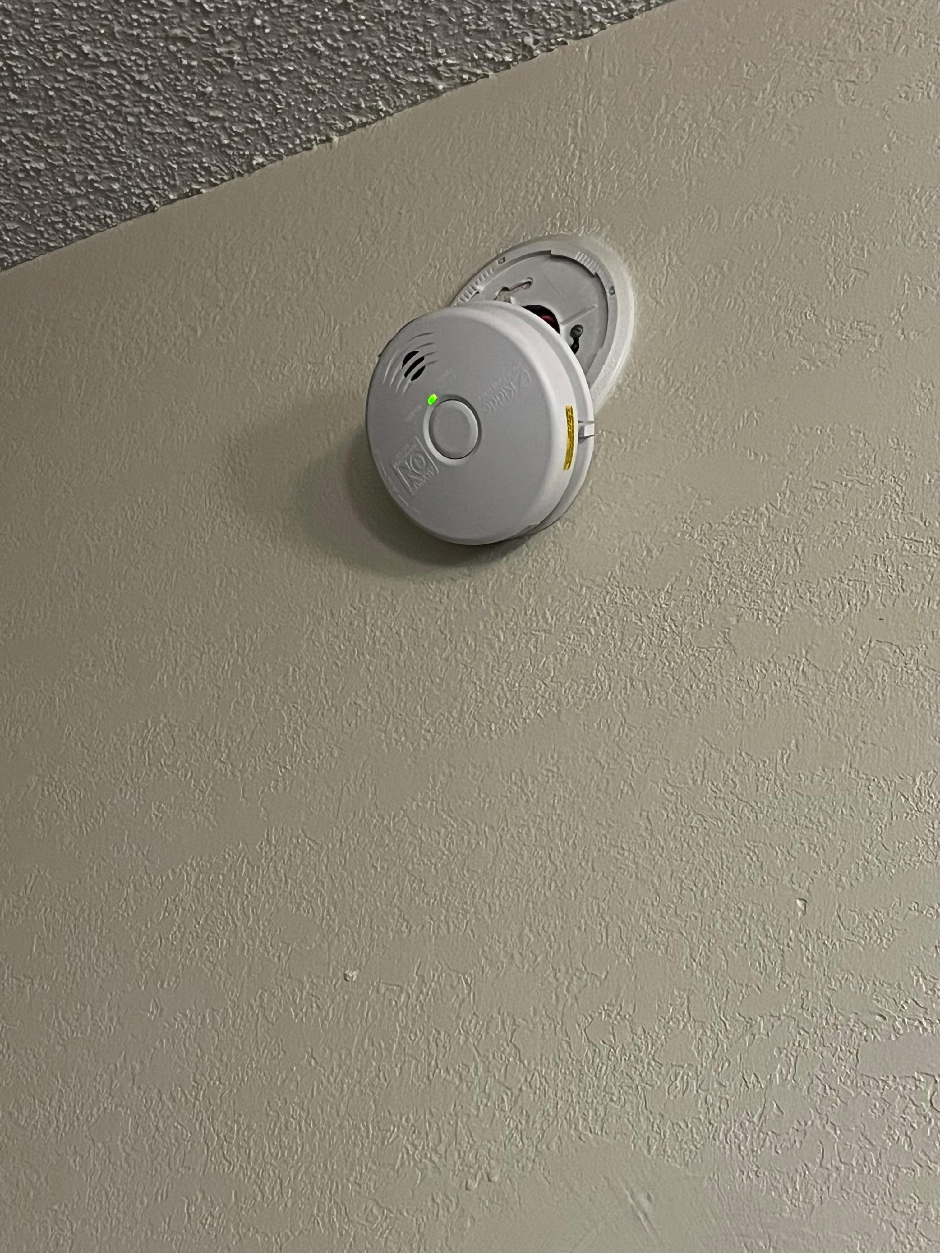Smoke detector hanging from wall 