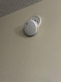 Smoke detector hanging from wall