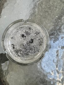 Balkon nicht gefegt, dreckiger Tisch und Aschenbecher
