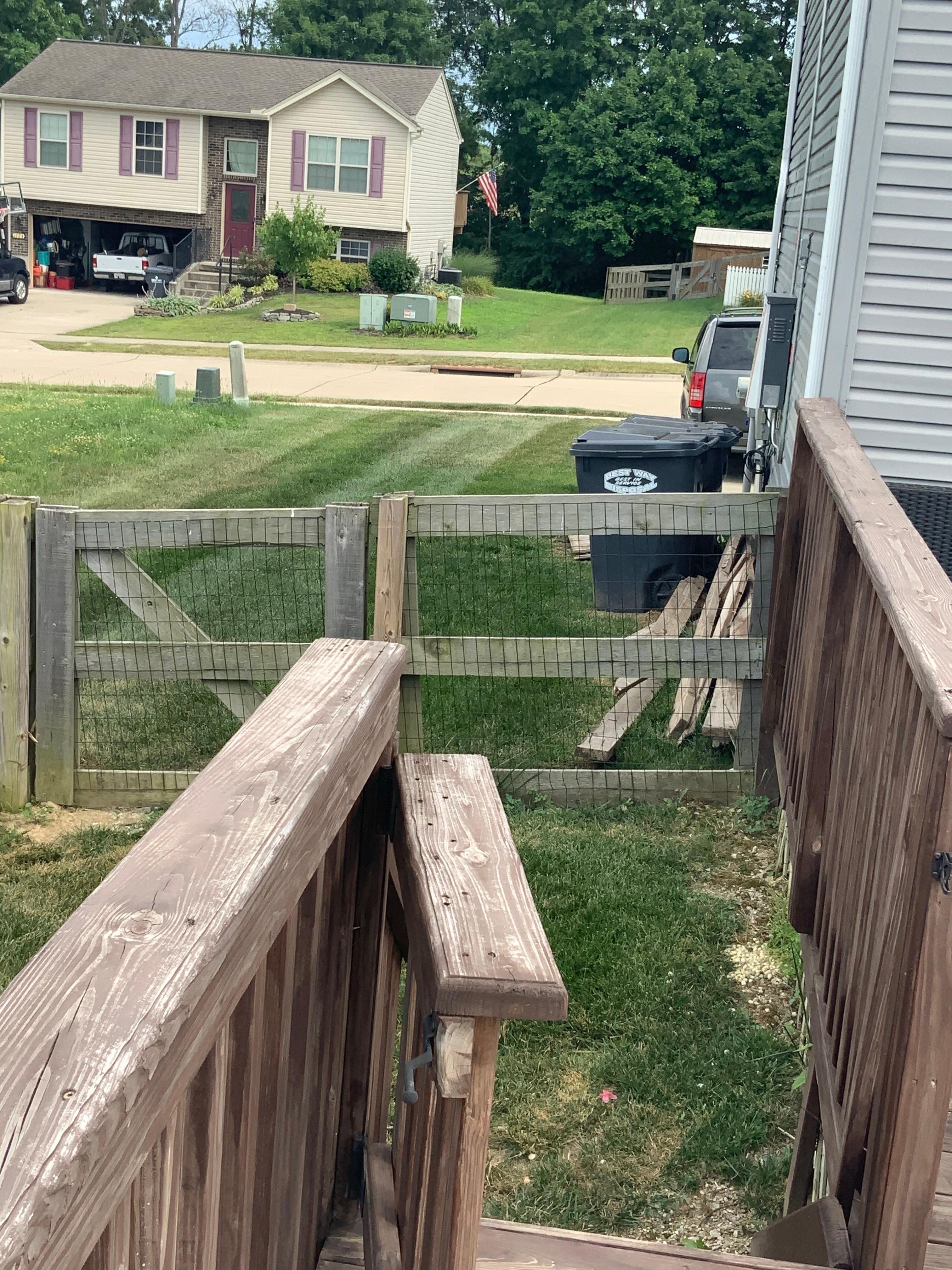 Piles of wood alongside the garage (there’s more in front of the the garbage cans)