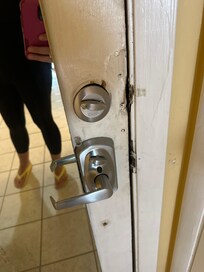 Entrance. Lock etc. the mirror (?) on the back of the door was damaged and dirty as well.