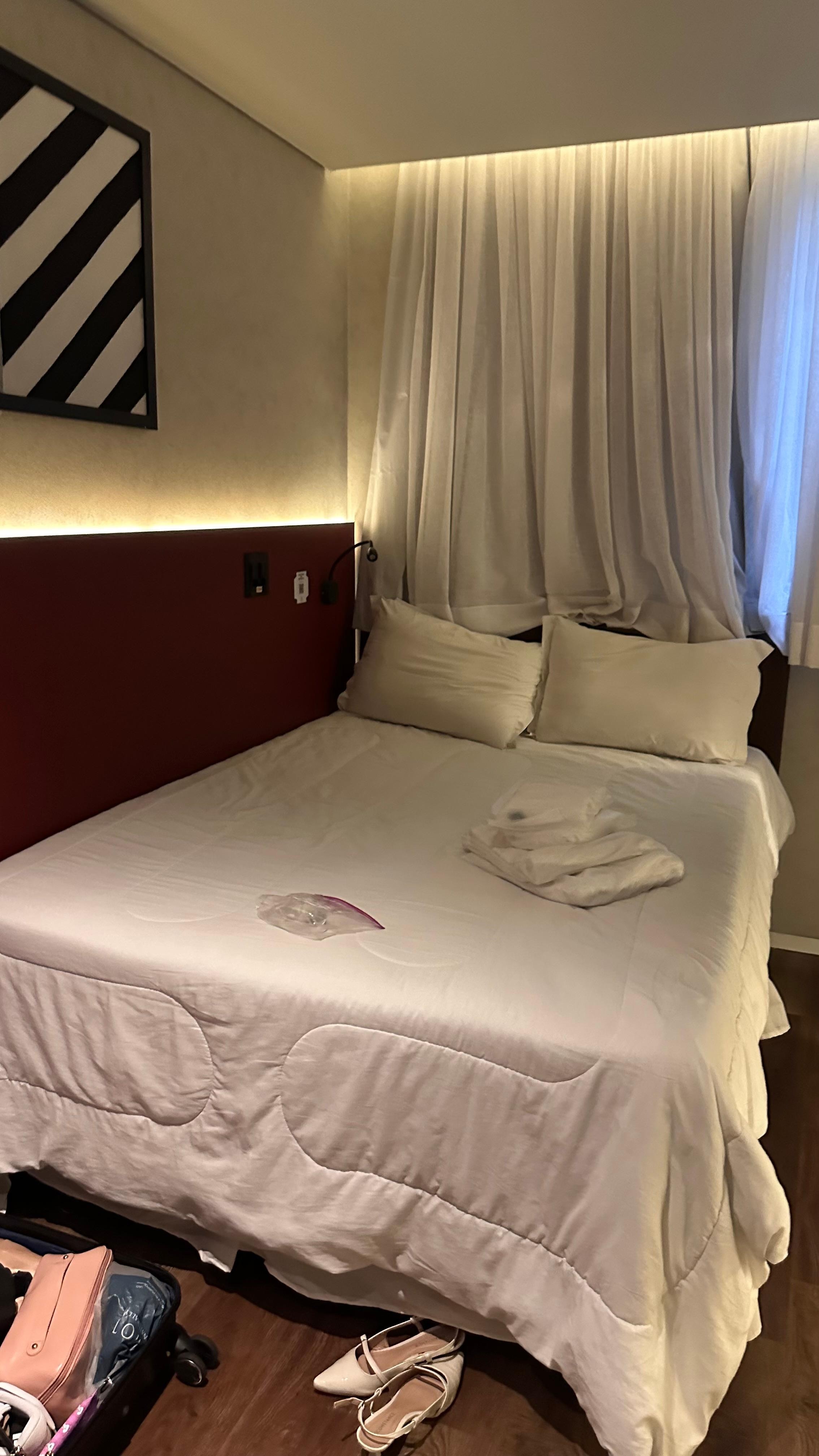 Quarto com roupa de cama que não foi trocada .