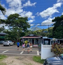 The view from the front yard. There are little shops across the street (a market, coffee shop, & shave ice place). The shuttle stops right there.