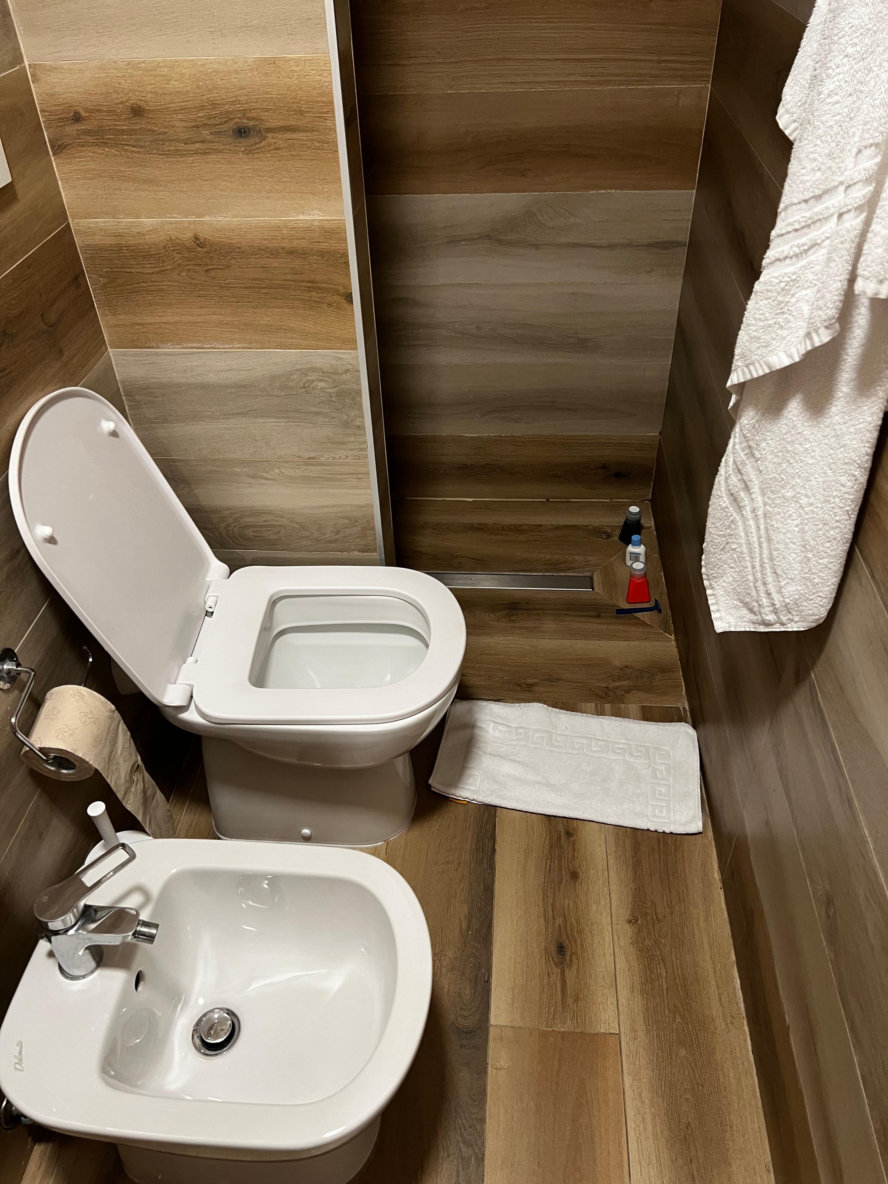 Floor gets wet. As an American I would rather have a wider shower than a bidet.