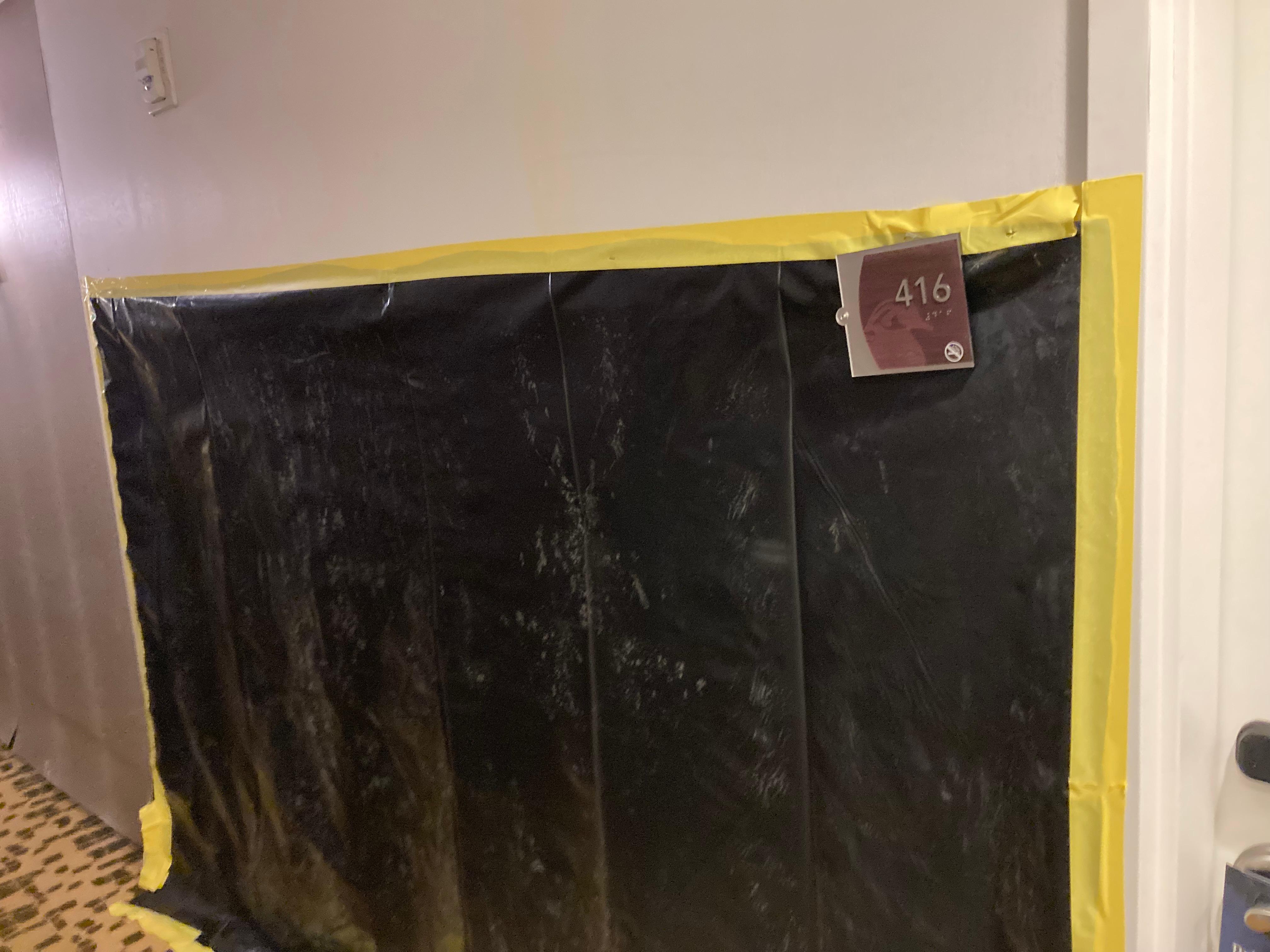 Wall completely missing so covered with black plastic outside of room