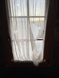 A torn curtain in the master bedroom en-suite.