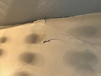 Large crack and bulging area in wall in bathroom near ceiling (walls are plaster)