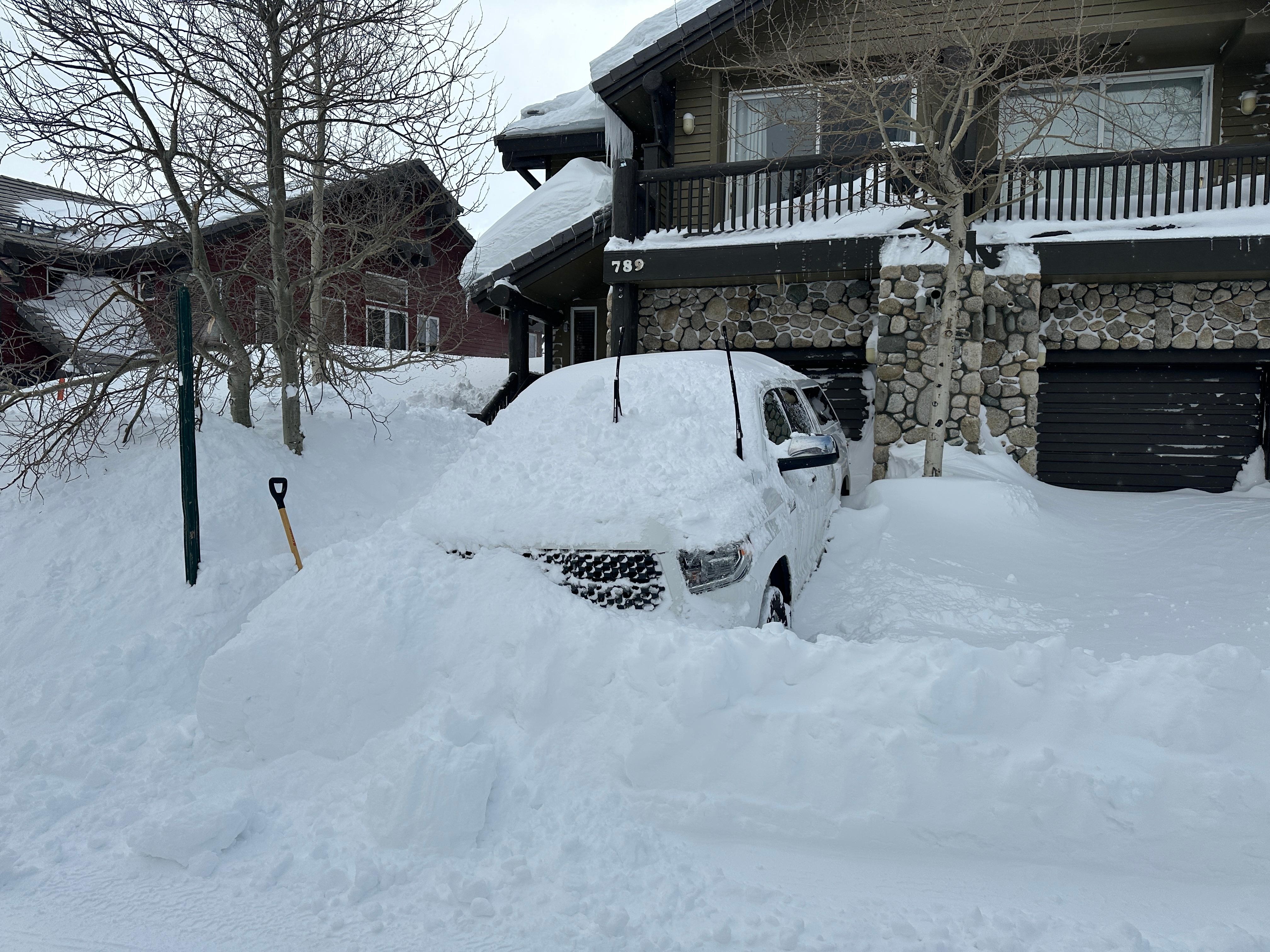 Truck buried in Snow in front of the Garage.