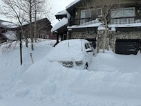 Truck buried in Snow in front of the Garage.
