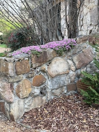 Charming rock walls, arches, and flowers give it a quaint and comfortable feel.