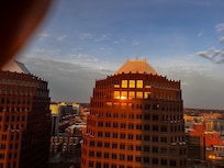 Looking west from my hotel window, the sunrise reflected in the building across the street .