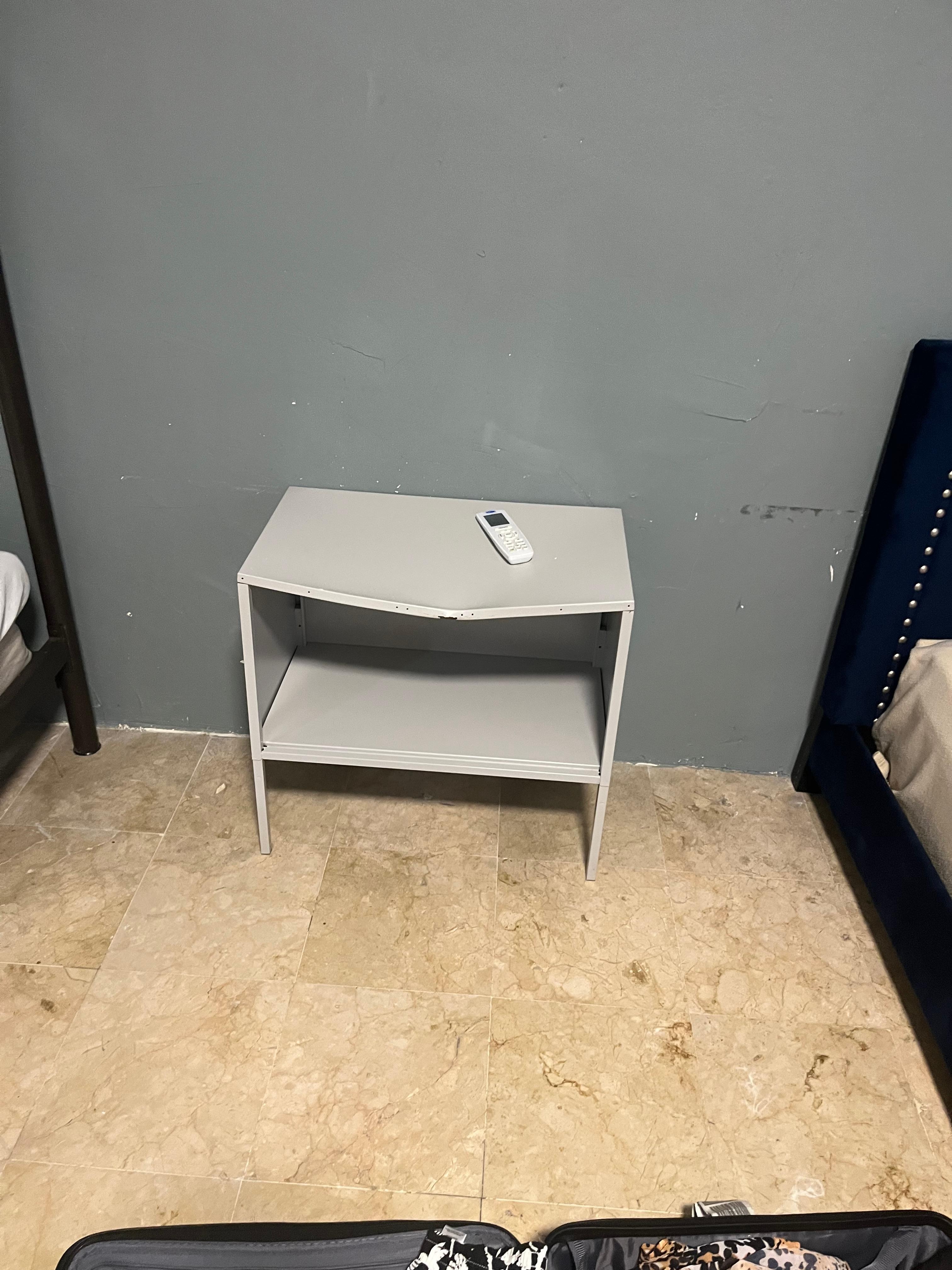 Bent nightstand in the poorly furnished bedroom 