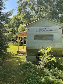 The outside of the camper. Cute and slightly secluded. The perfect little porch.