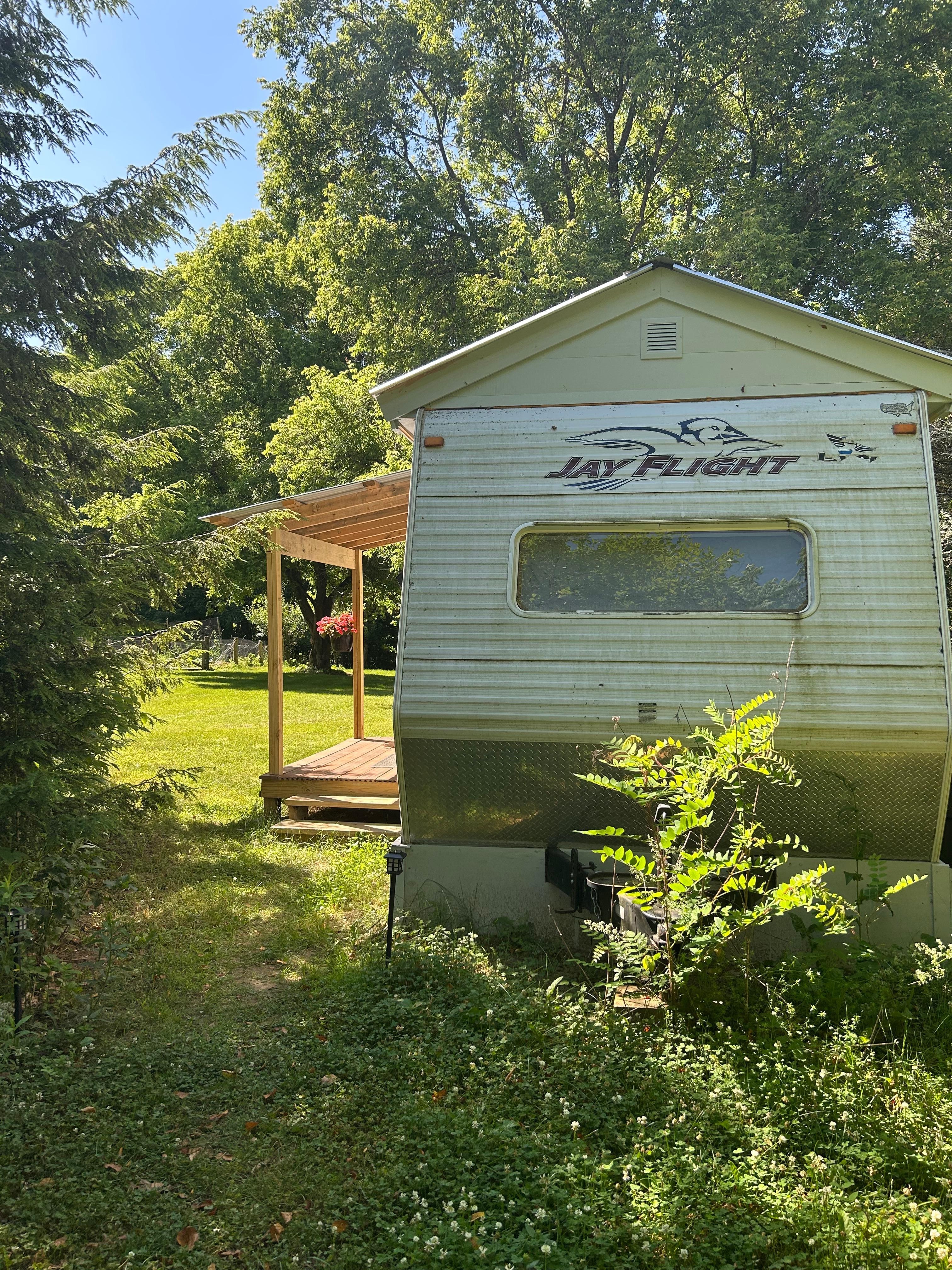 The outside of the camper. Cute and slightly secluded. The perfect little porch.