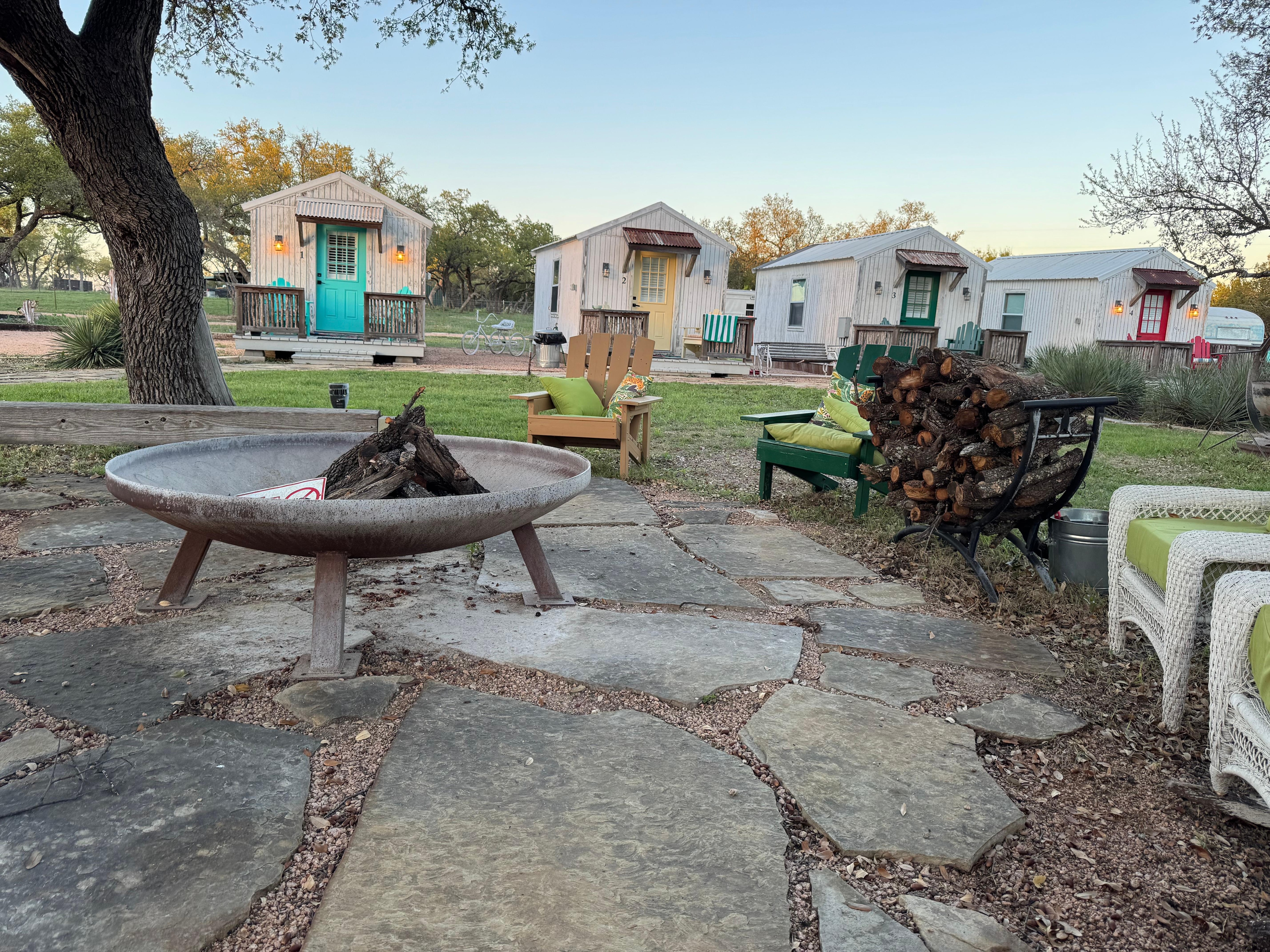 Cabins and partial view of fire pit with seating area.