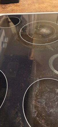 Dirty stovetop with stuck on food.