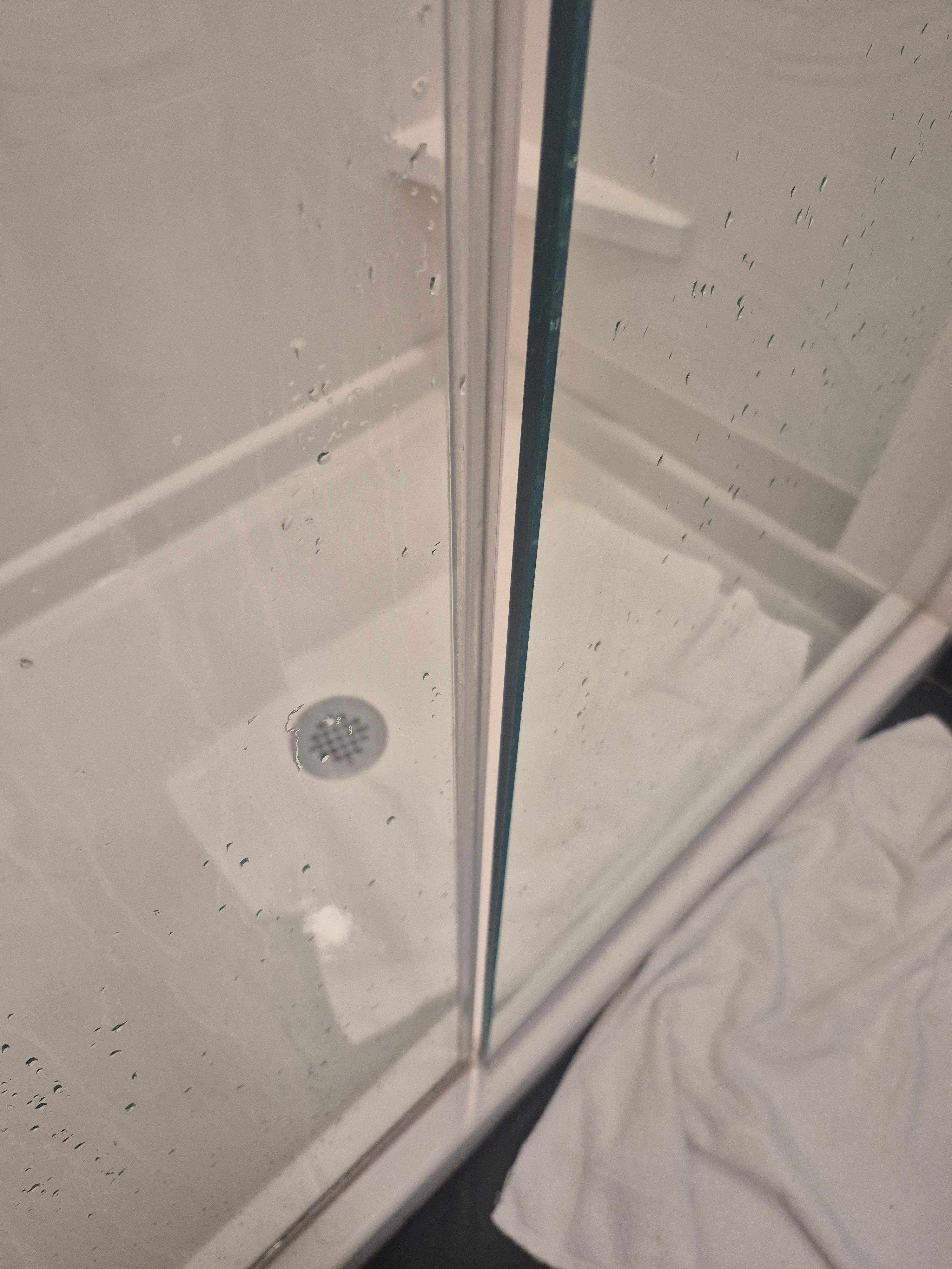 A gap between door and glass let water spray on the floor