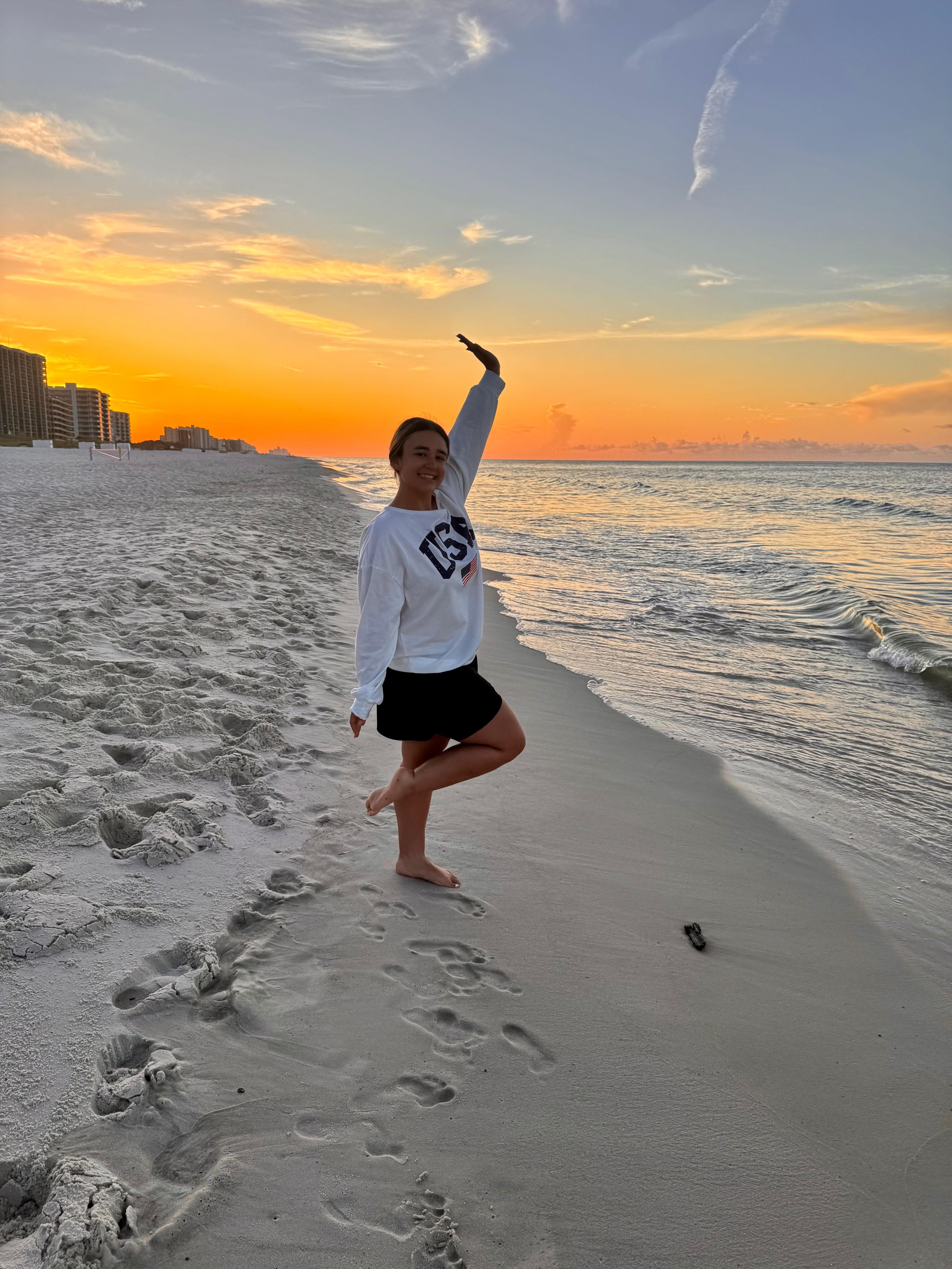 My daughter with the sunrise right in front of condo
