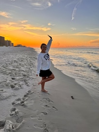 My daughter with the sunrise right in front of condo