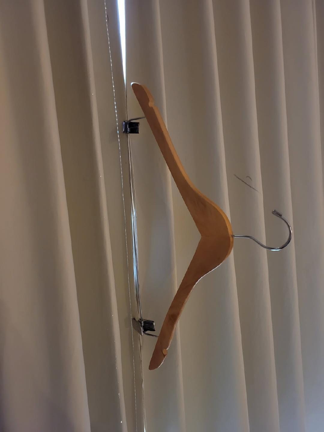 Pants hanger to keep curtain closed