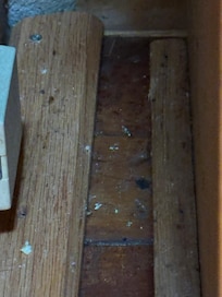 Floor beside trash can.