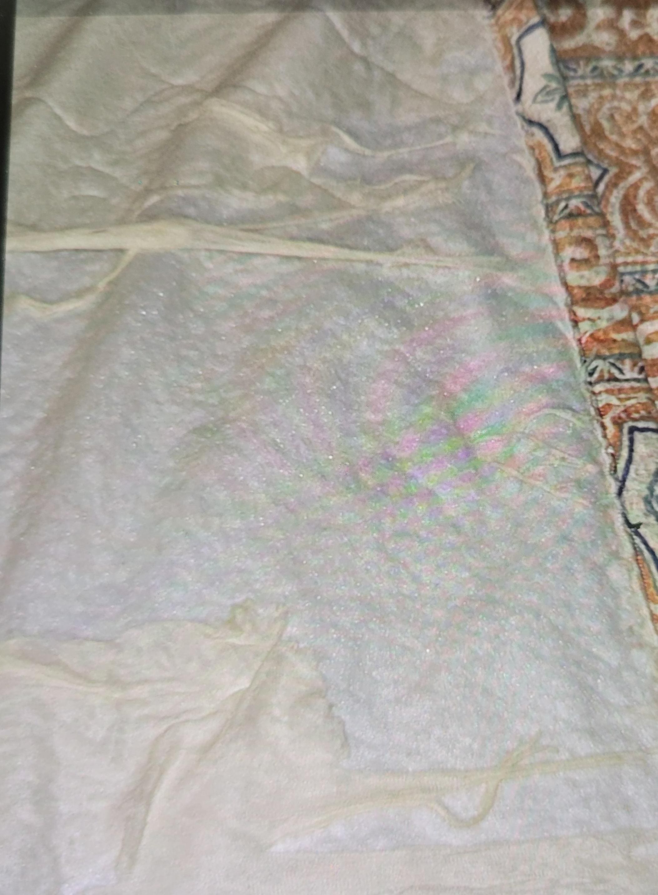 Tattered comforter at the top of bed 2