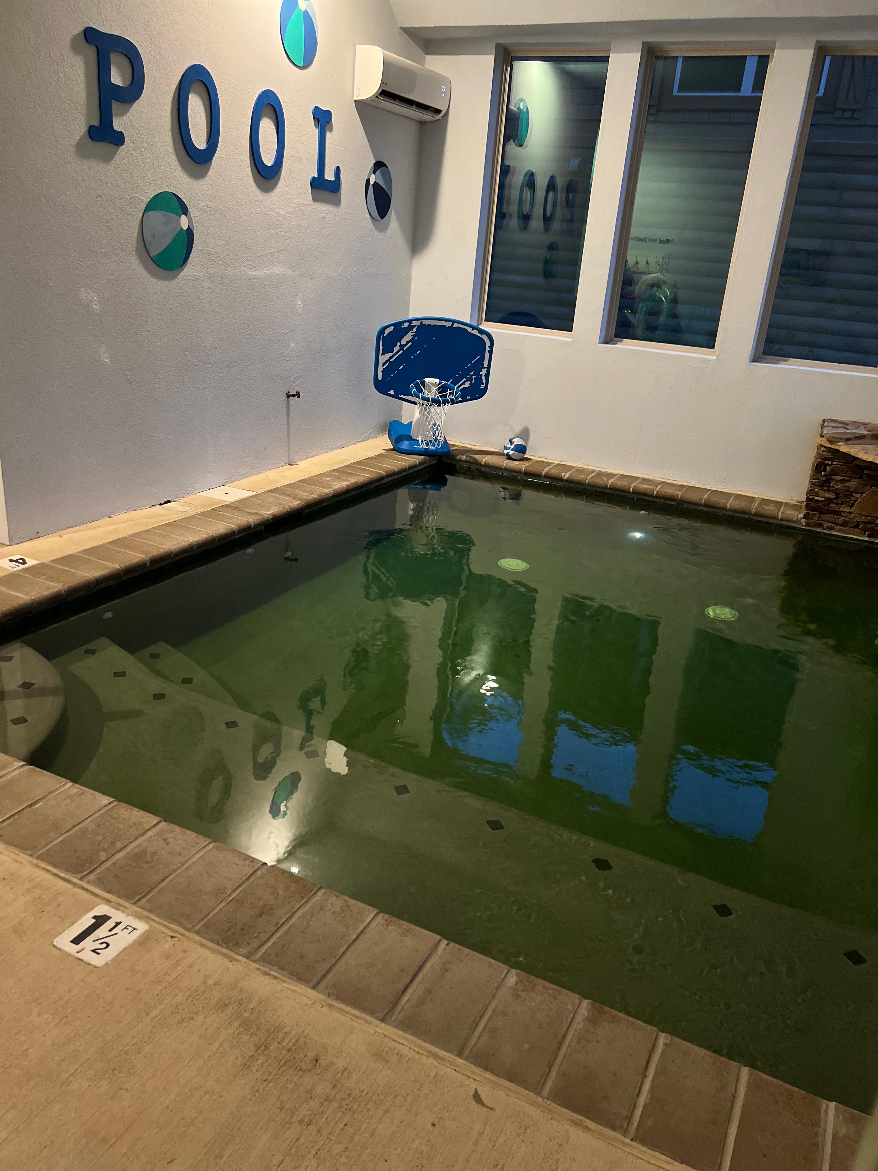 The water has a green hue due to the pool floor color.